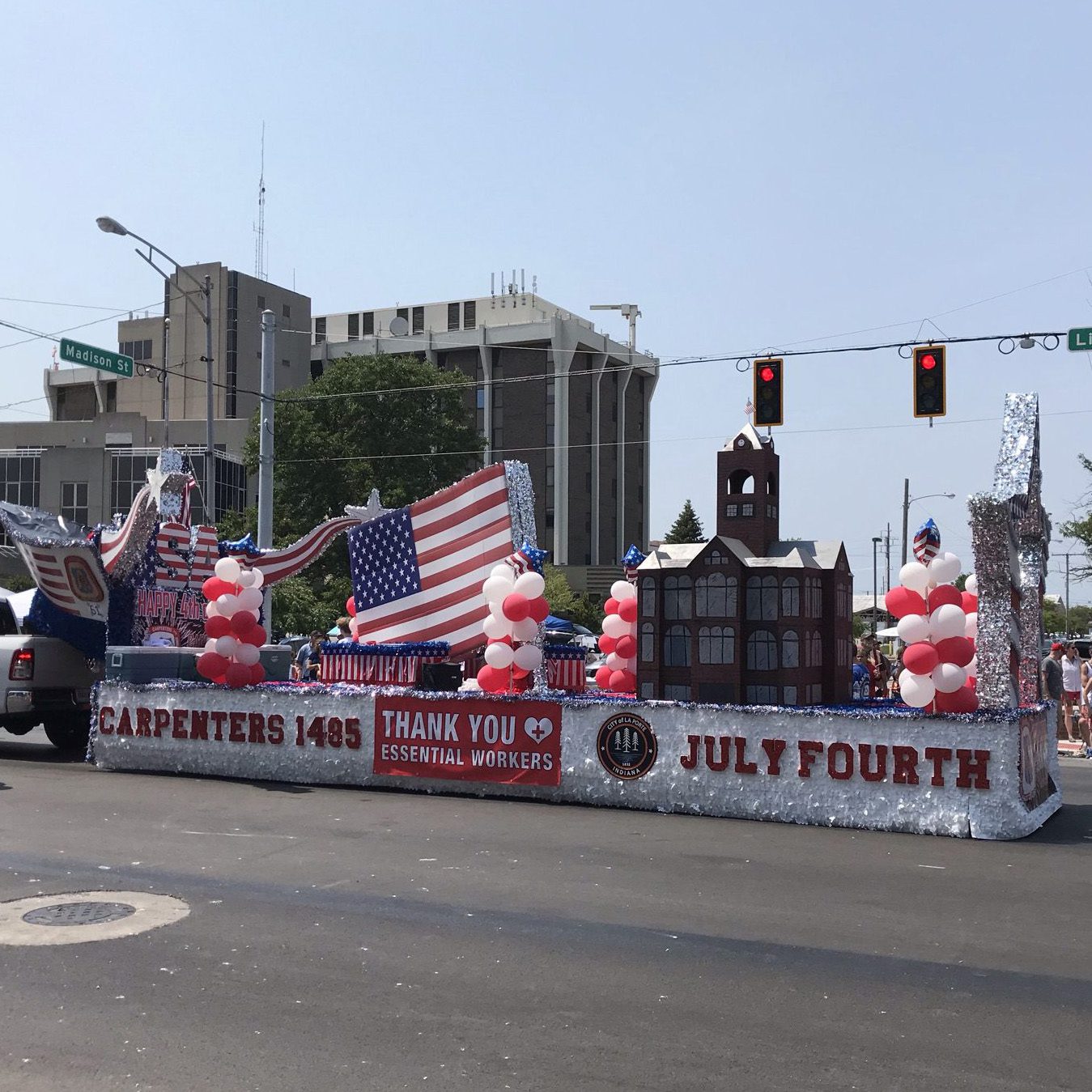 Carpenters Local 1485 float at the Kiwanis Fourth of July Parade in LaPorte, Indiana featuring American flags, red and white balloons, and a “Thank You Essential Workers” banner during the Independence Day celebration.